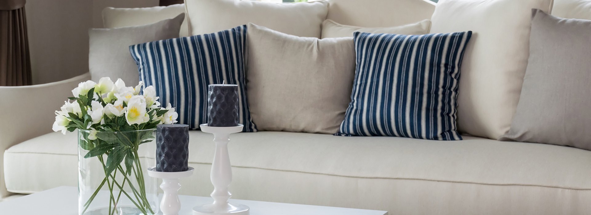 modern living room with glass vase and row of pillows on sofa